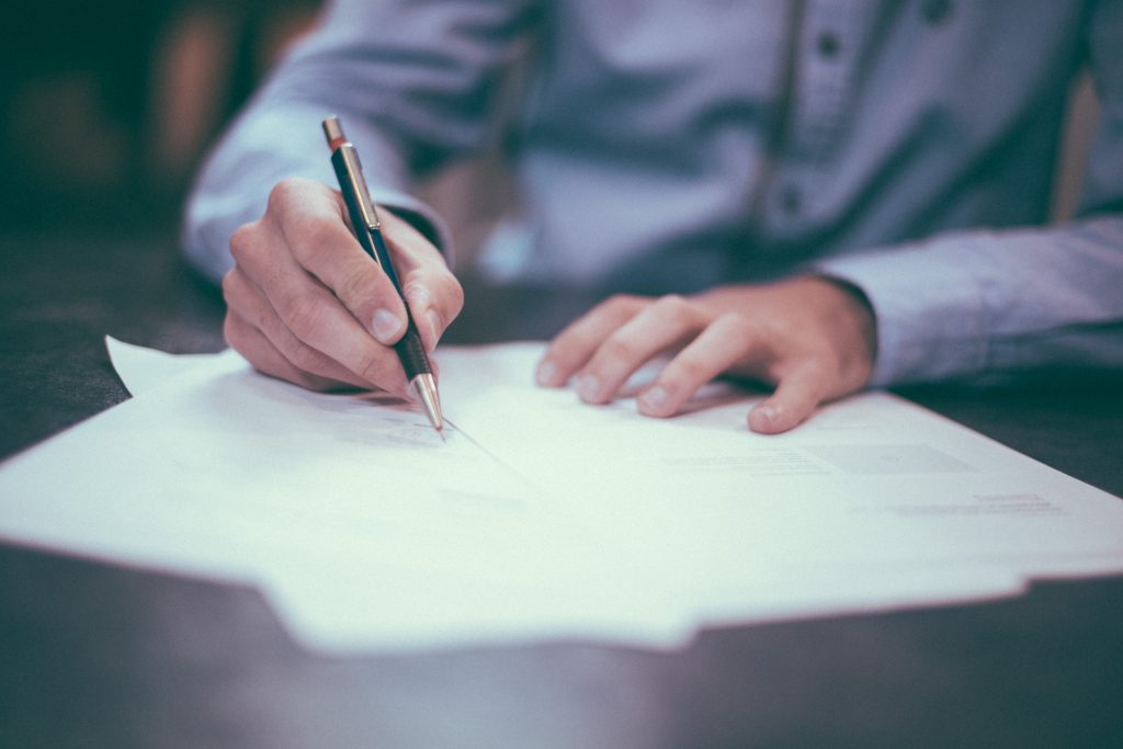 Close-up of hands signing a document