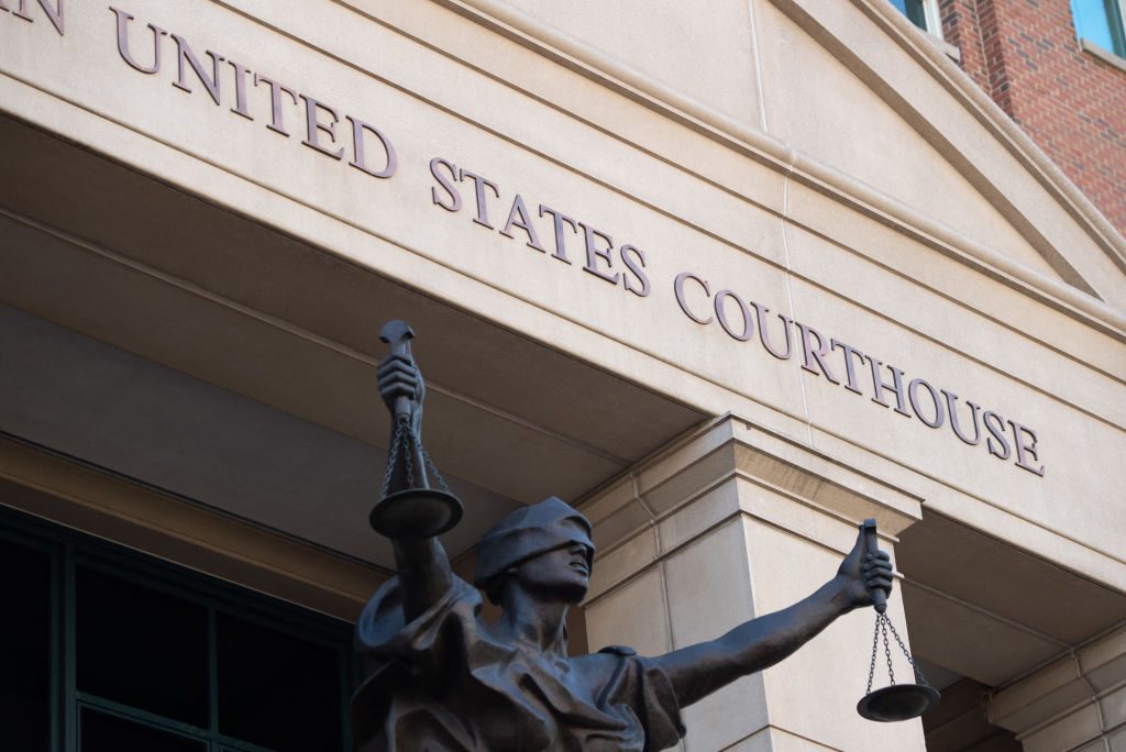 United States courthouse with scales of justice statue in front