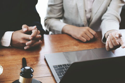 Lawyer consulting client in front of laptop