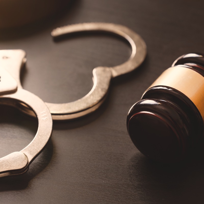 Gavel and handcuffs on table