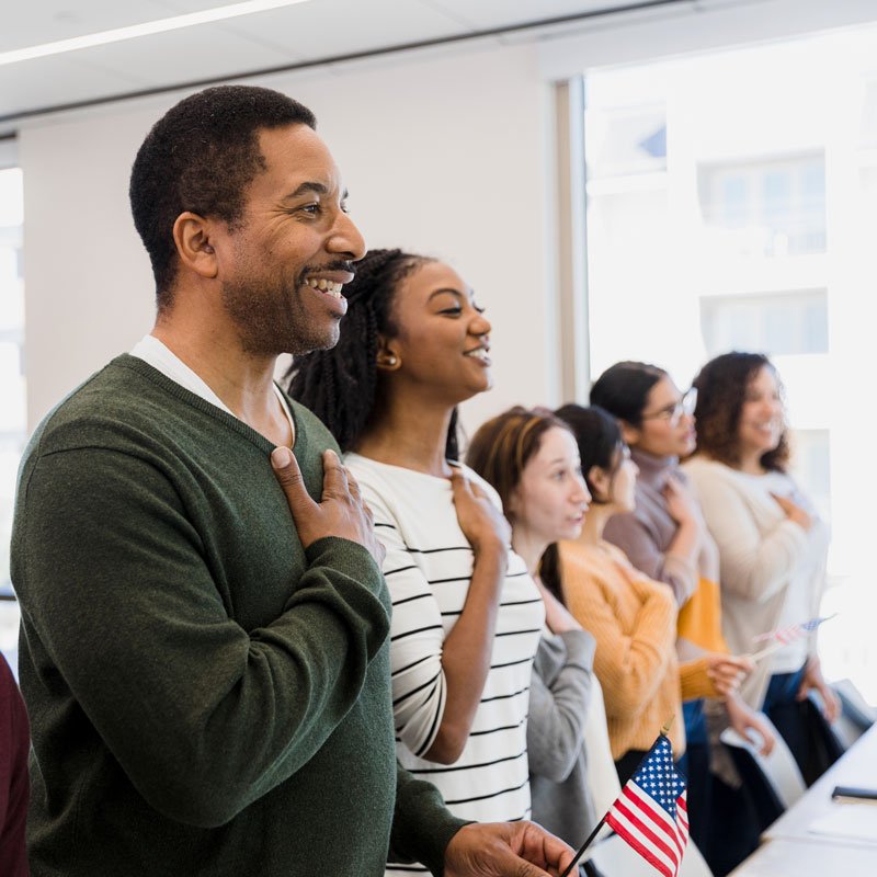 Group standing with flags during a citizenship ceremony related to immigration in Ogden, Utah