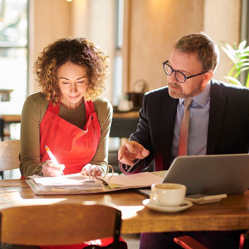 A person at a desk signing small business documents from a corporate attorney in Ogden, Utah