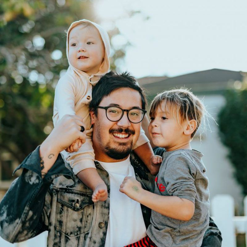 Domestic partnership caring for children outdoors with an adult holding two young kids in Ogden, UT